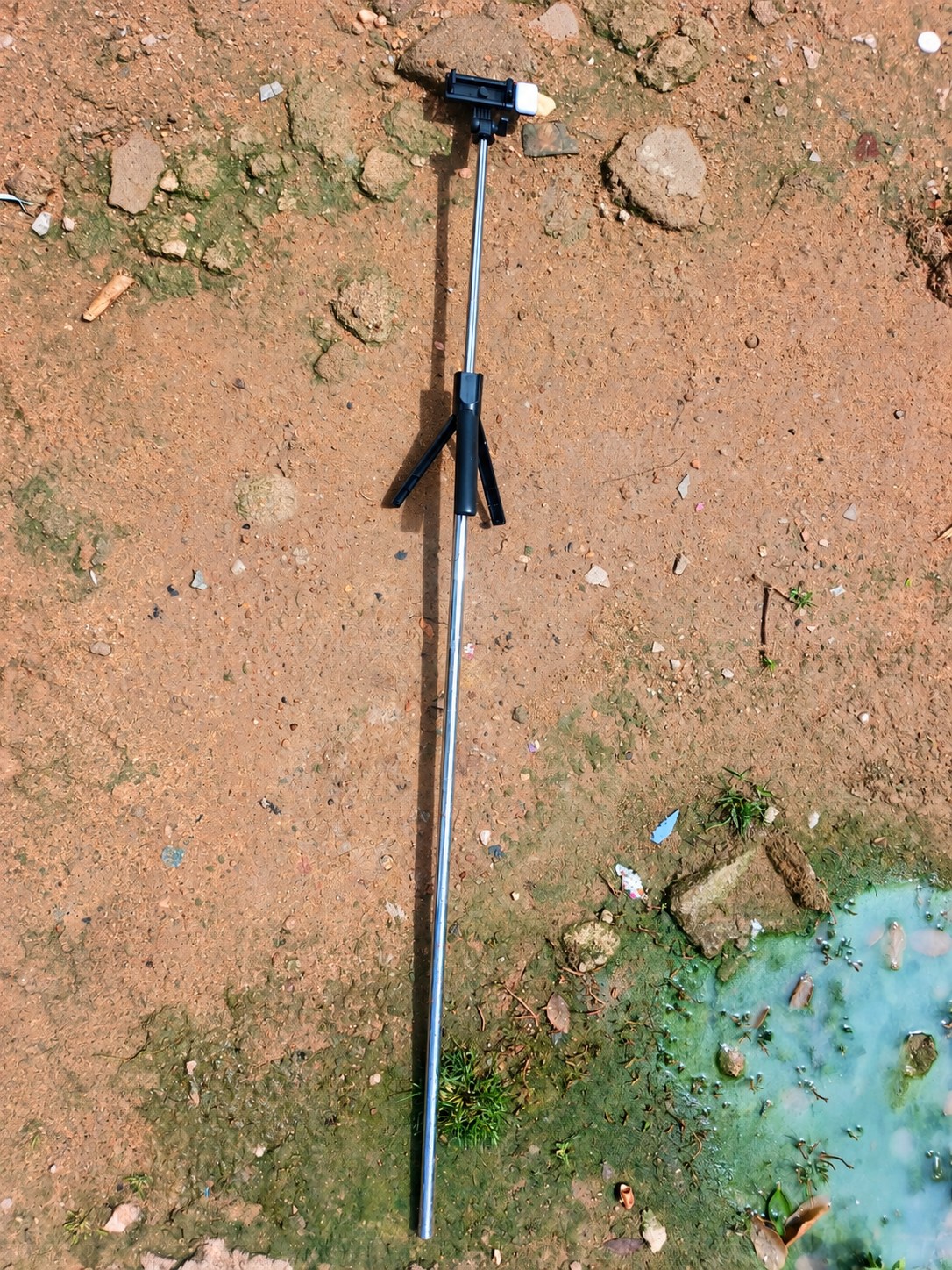 Canne à selfie rallongée par un tuyau en métal, avec le support du téléphone fixé