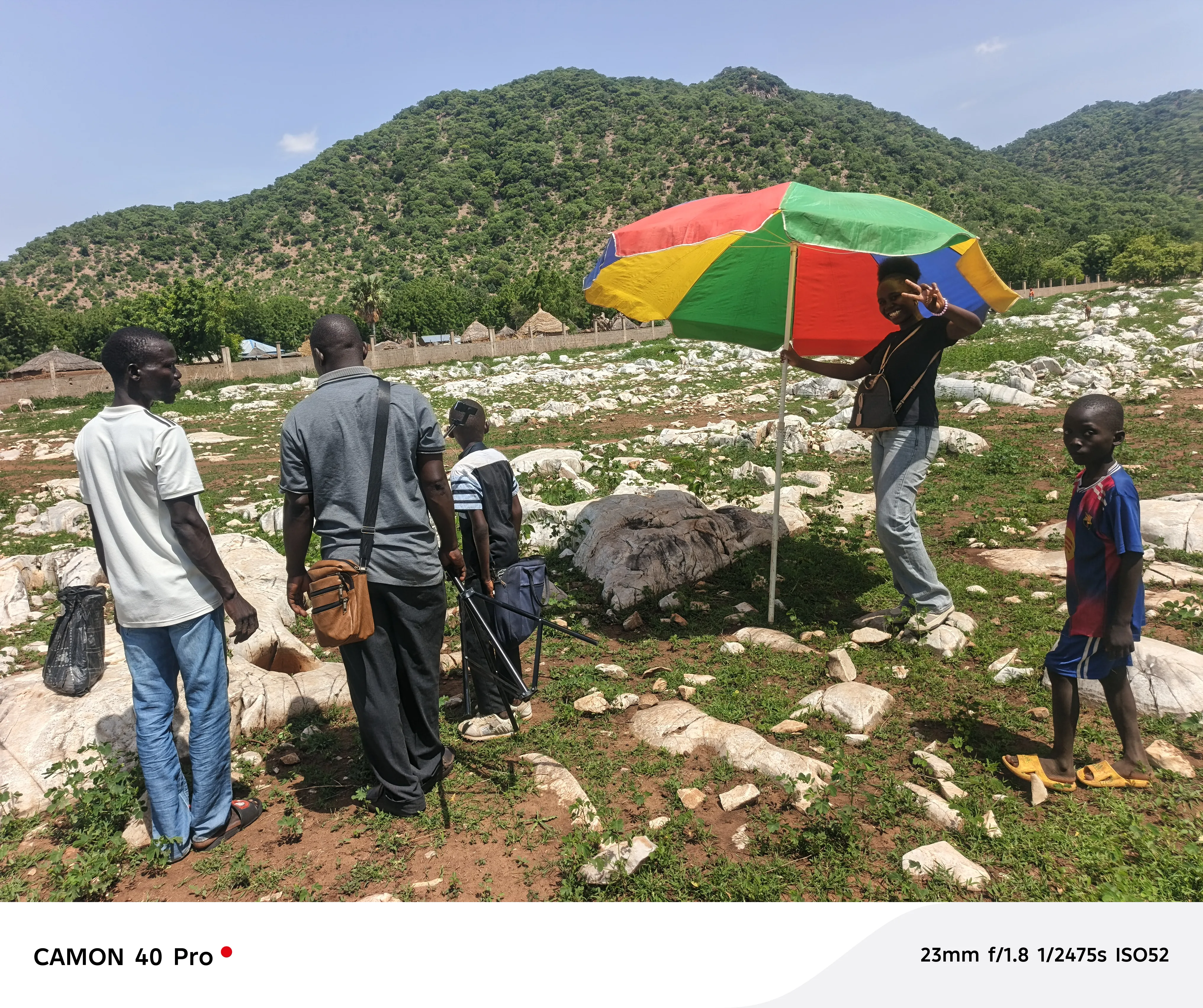 Installation du dispositif sur le terrain à Bidzar, sous un grand parasol coloré, avec l'équipe